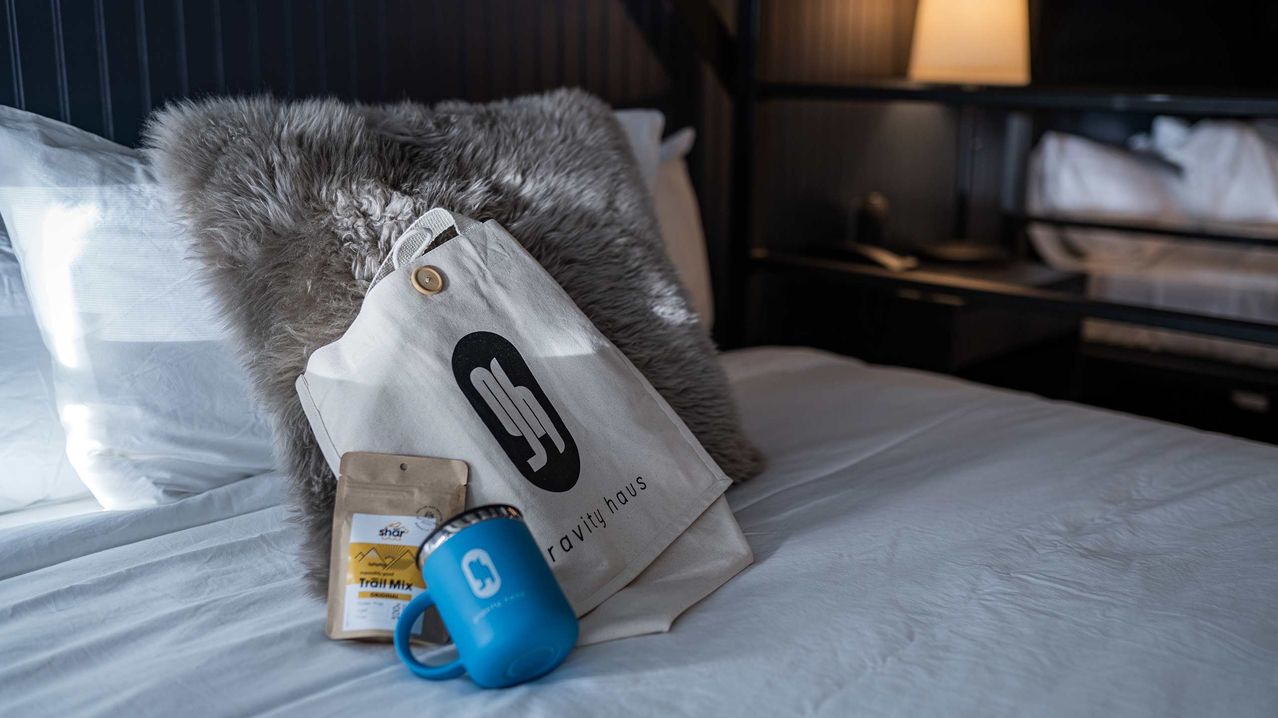 Gravity Haus Winter Park Idlewild King Bed Detail with branded mugs and bag