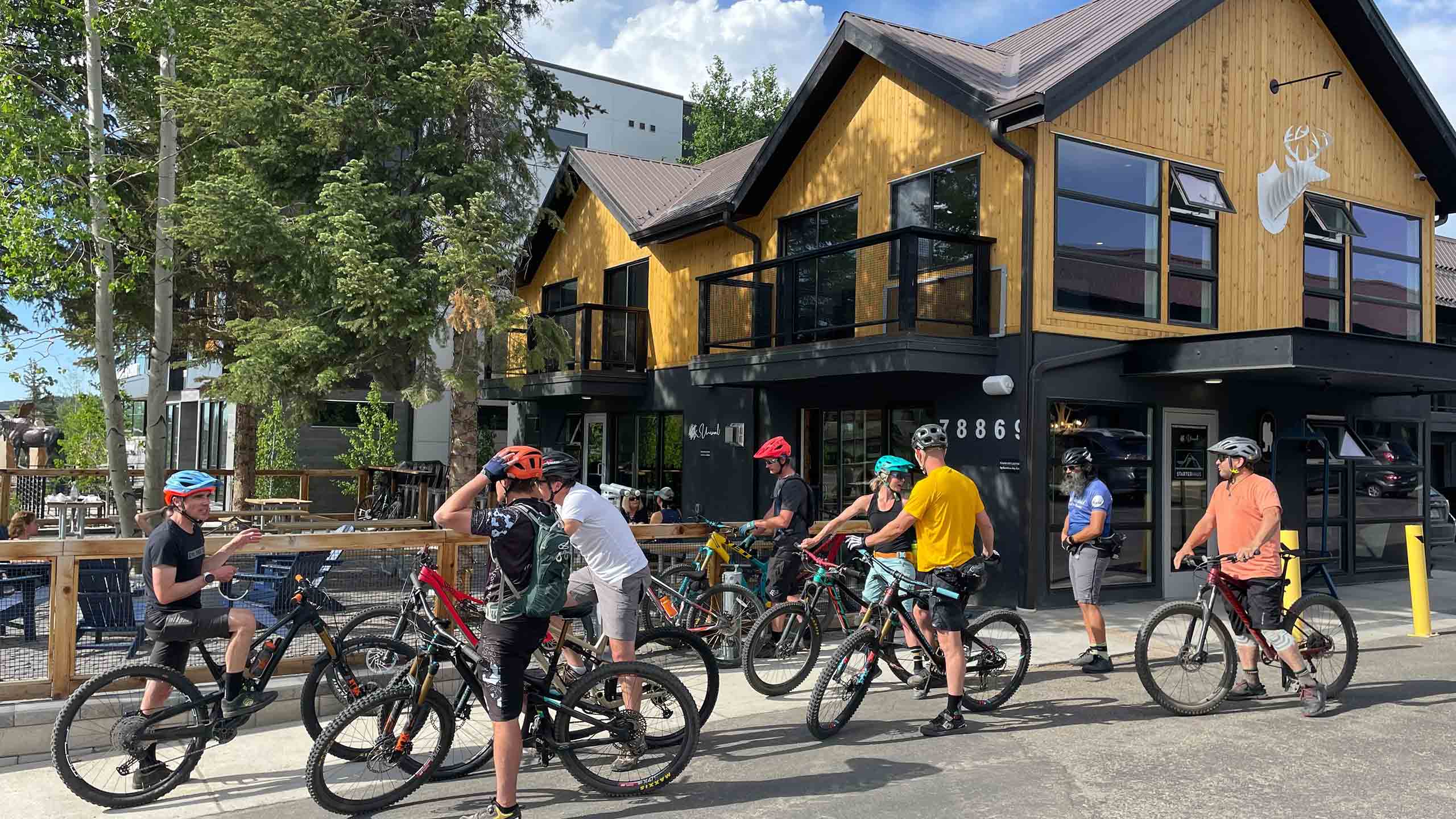 Gravity Haus Winter Park guests gathering outside with mountain bikes.