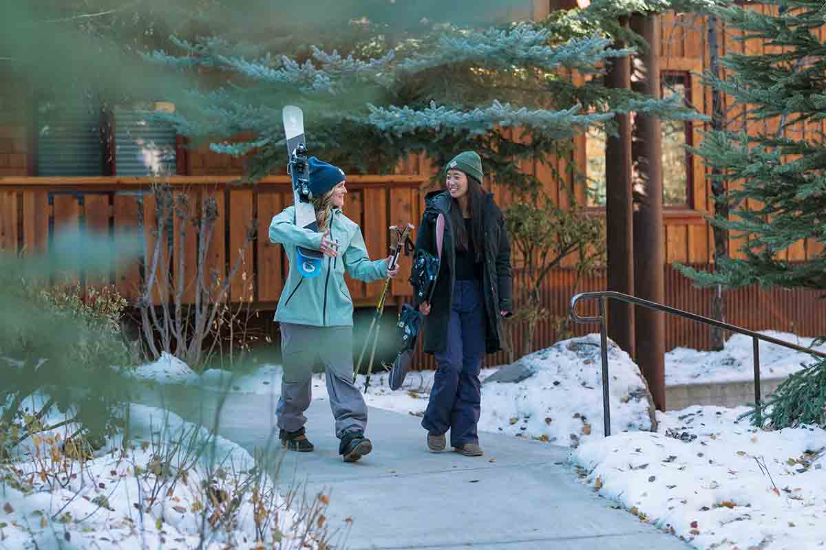 Two Gravity Haus Truckee-Tahoe guests walking outside with Haus Quiver ski gear.