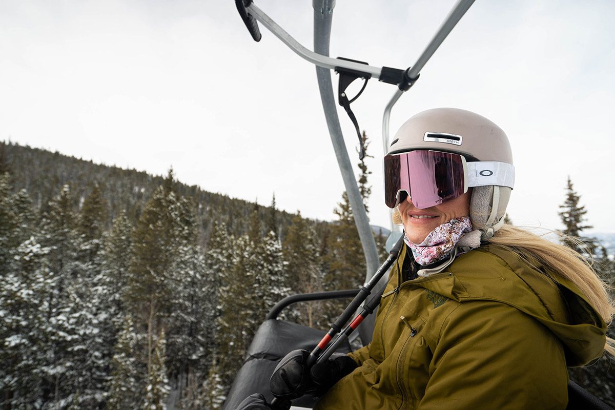 Rachel Carpenter with goggles and helmet riding a chairlift at Breckenridge on an overcast day.