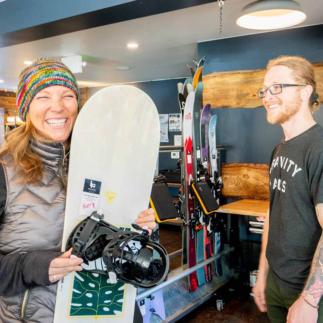 Kerry Crandell receives her snowboard from a Haus Quiver Winter Park teammember.
