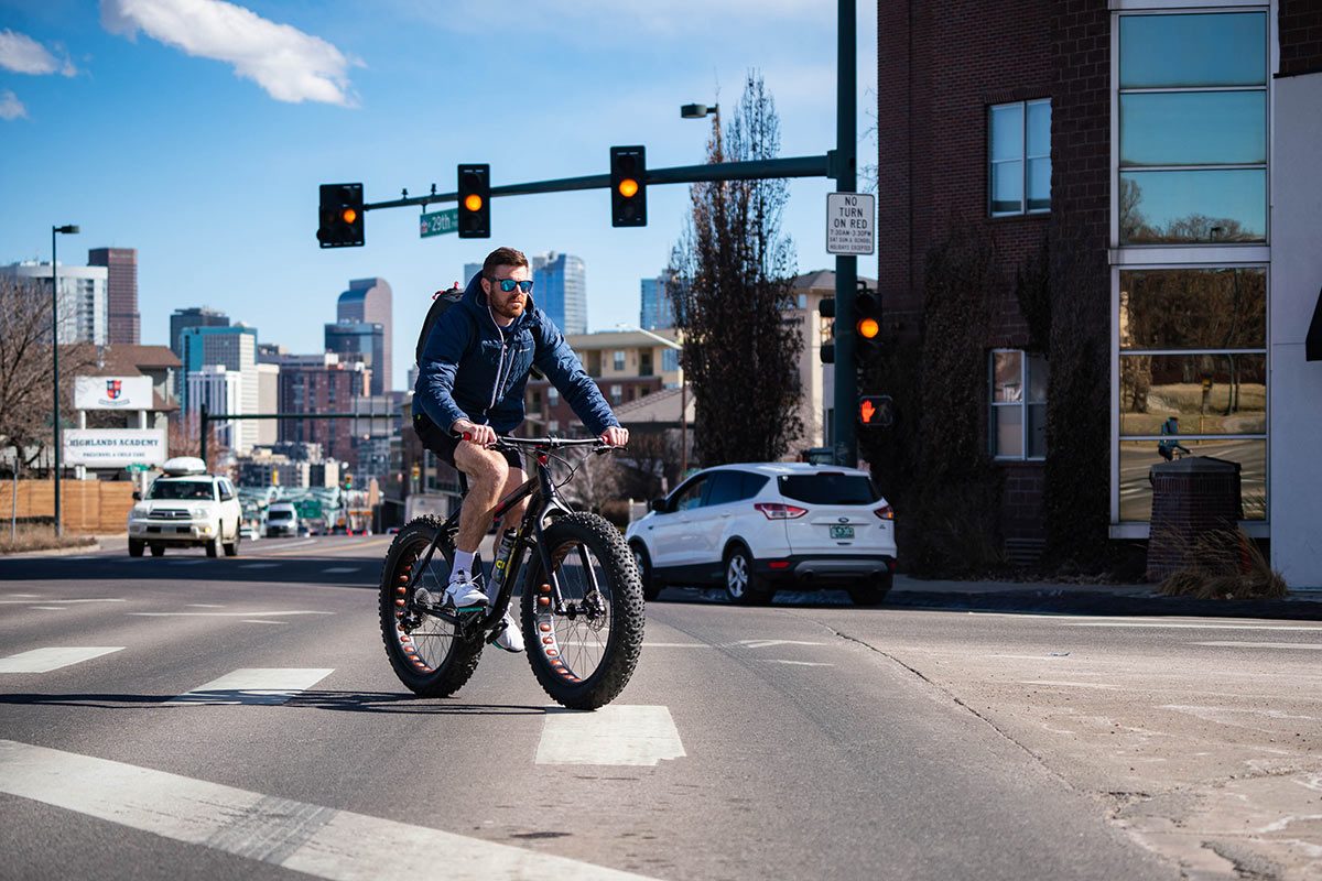 Ross Shuket rides a fat tire mountain bike on the streets of Denver on his way to Gravity Haus