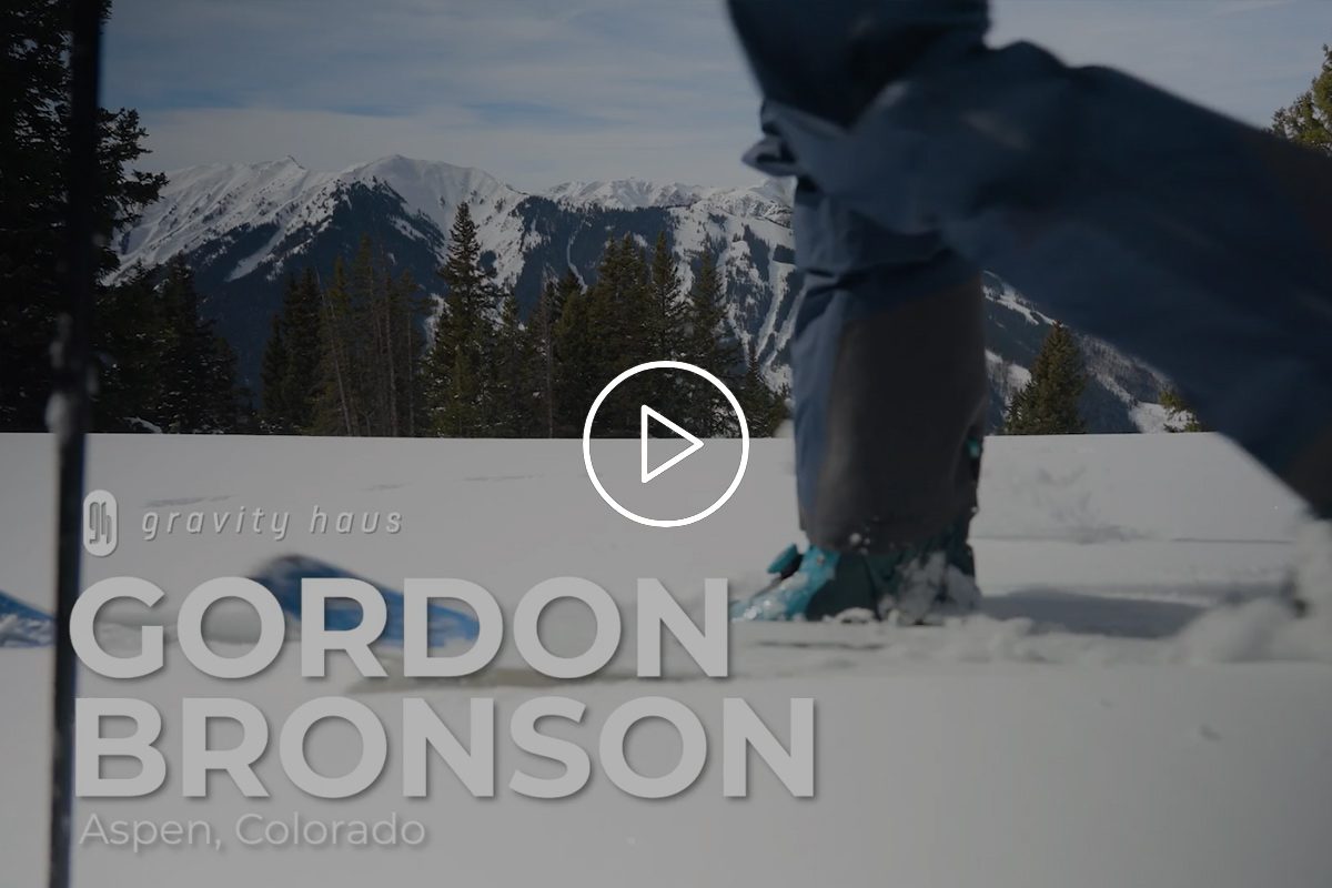 Close up of Gordon Bronsons legs as he skins up a slope with legs with view of snowy Aspen mountain peaks in background