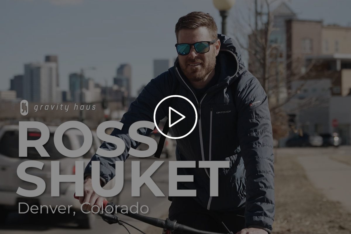 Ross Shuket riding mountain bike on Denver street with Gravity Haus logo and video title overlay